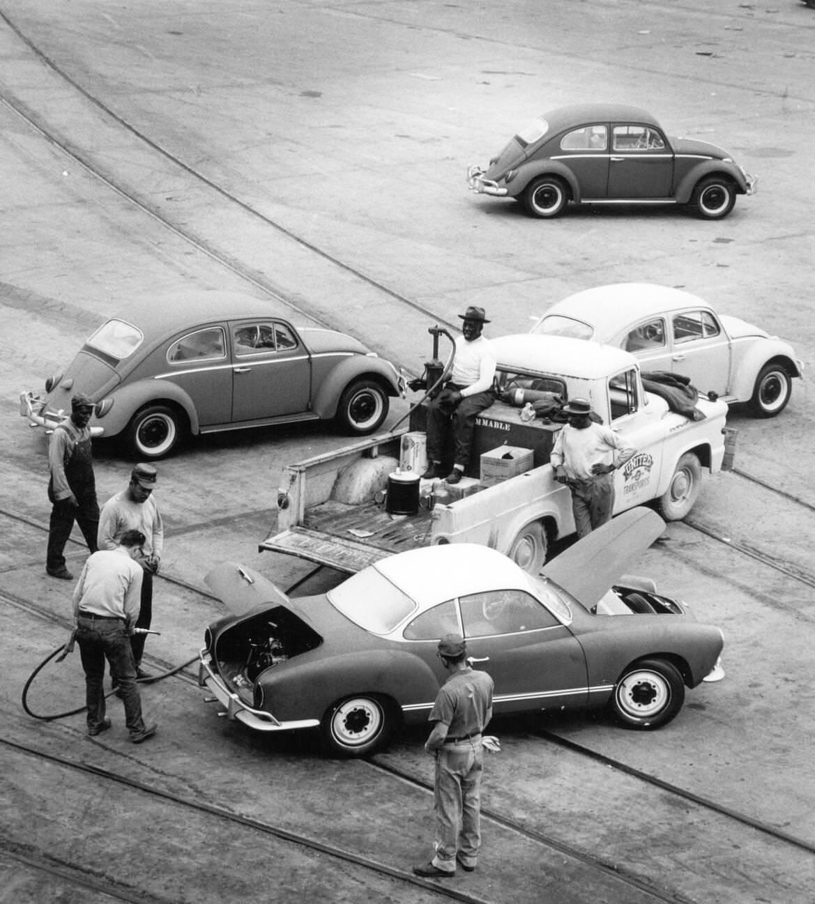 Volkswagen Beetles being refueled at the Houston harbor after importation, 1960s.