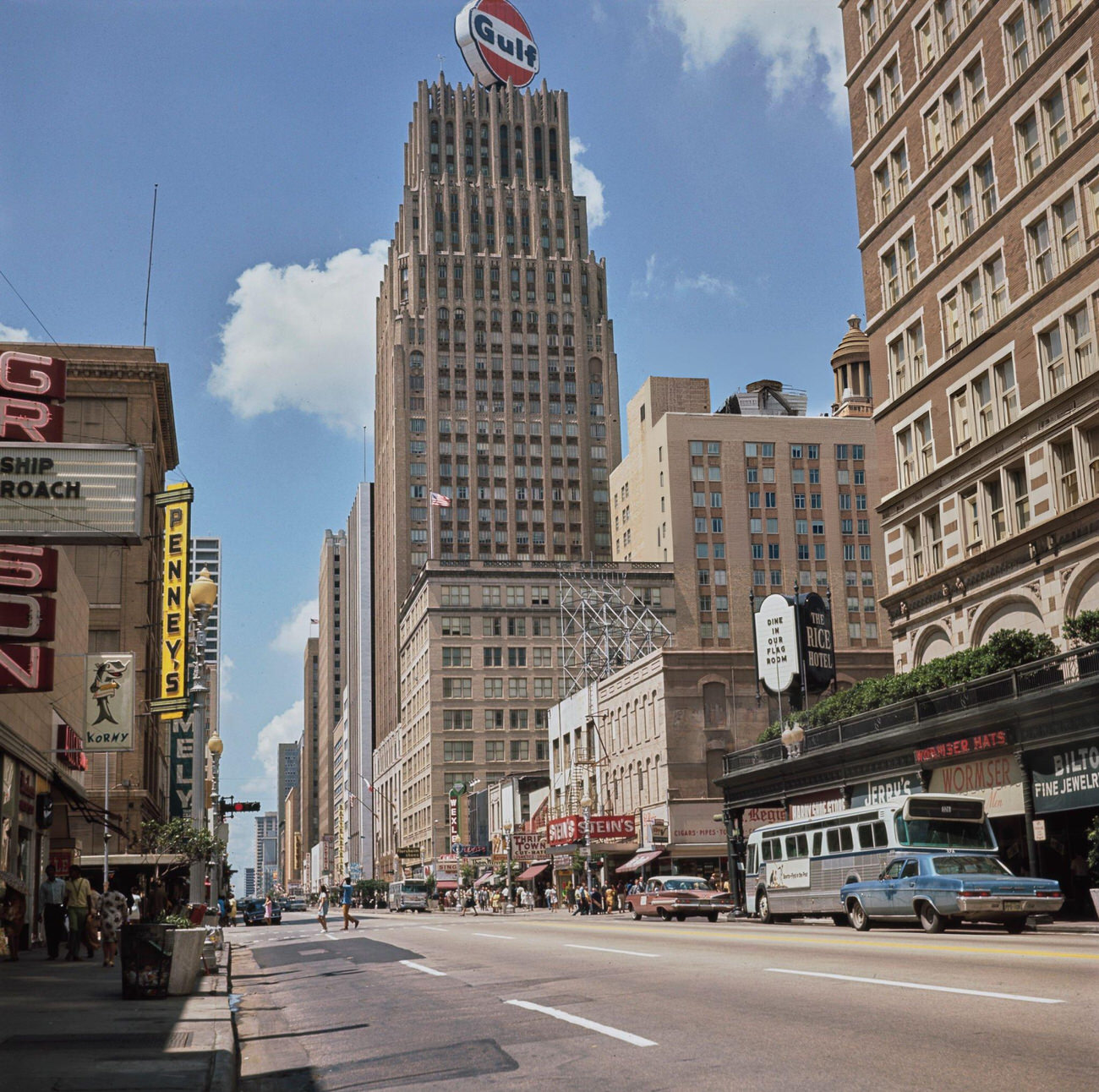 Main Street scene with cars and a bus in downtown Houston, featuring the Gulf Building, circa 1970.