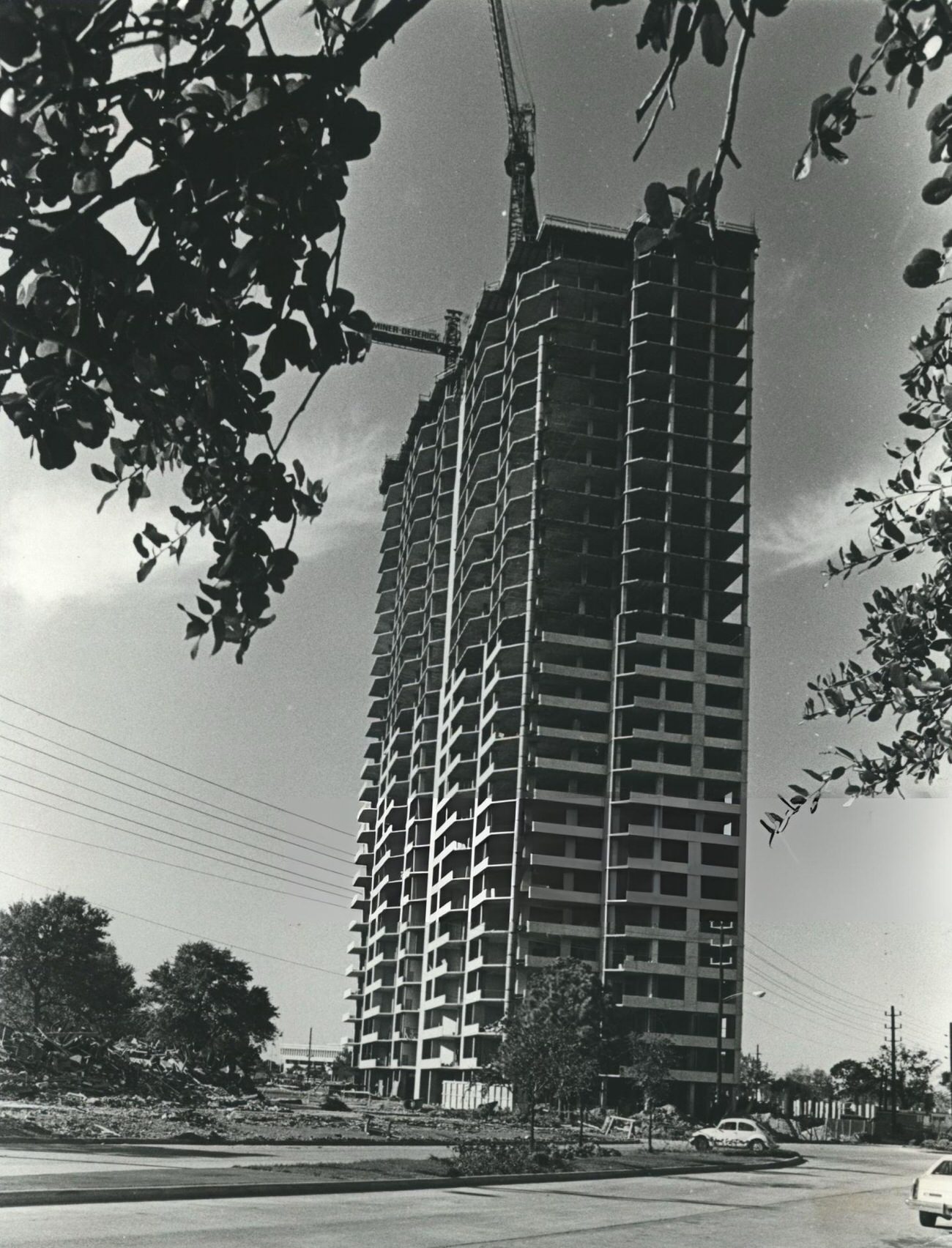 Greenway Plaza framed by tree limbs in Houston, Texas, detailing the Greenway condominium development.