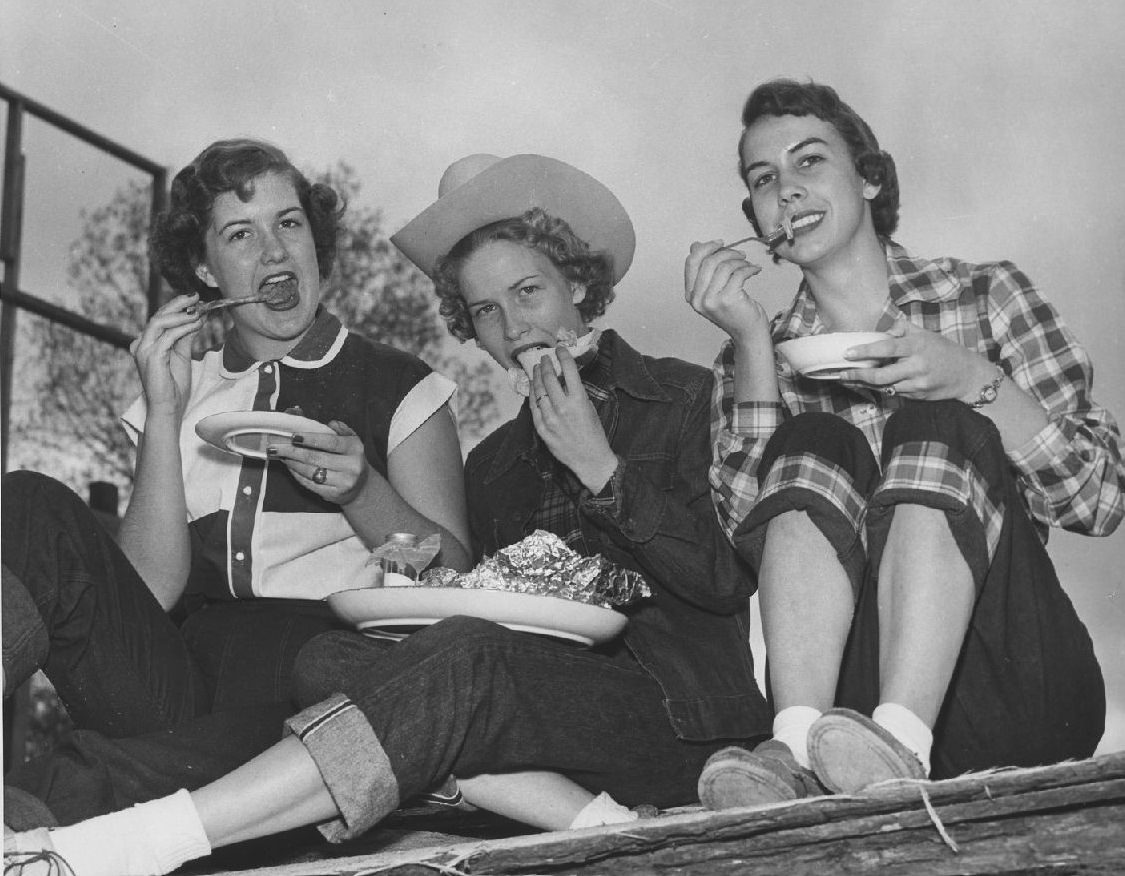 Three students eating at Frontier Fiesta, 1950s.