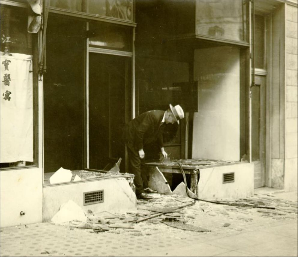 C. R. Lawson inspecting a damaged storefront at 614 Clay Street, 1926.