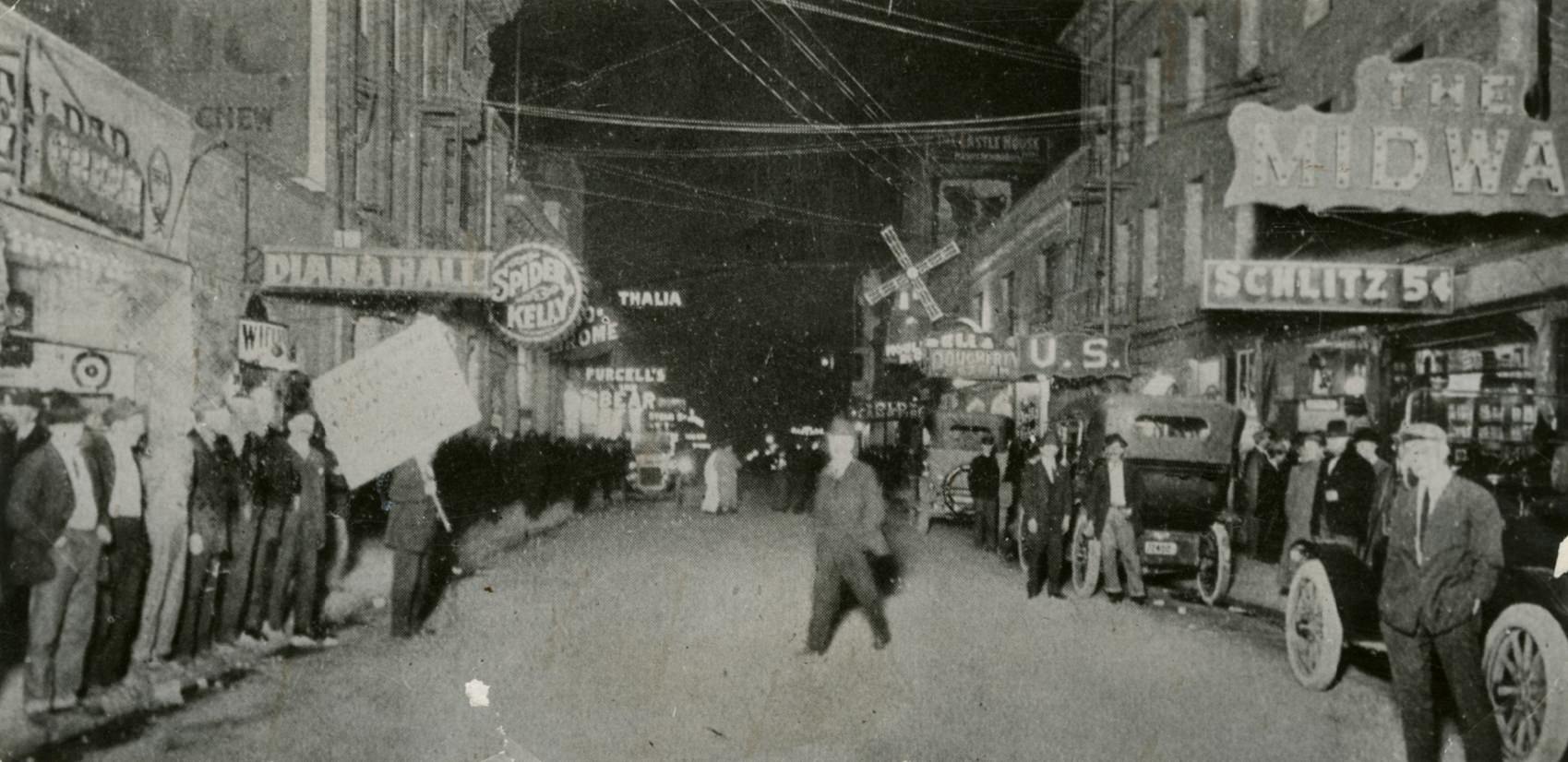 Busy nighttime street scene on Pacific Street in the Barbary Coast district, 1913.