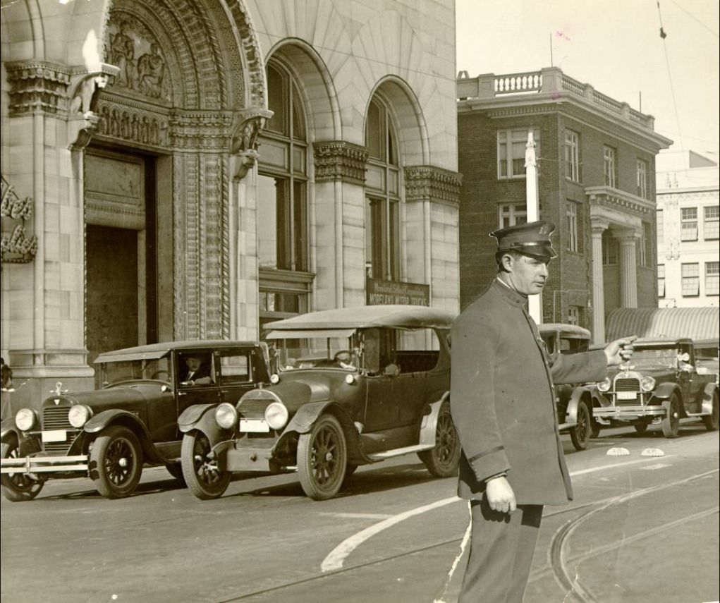 Van Ness Avenue at Market Street with a superimposed photo of a police officer directing traffic in 1927.