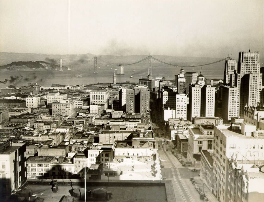 View of downtown with Bay Bridge under construction in the 1930s