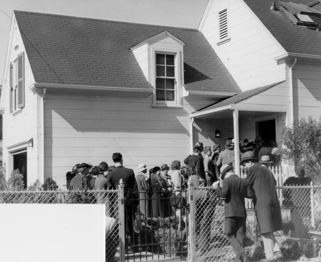 Crowd waiting in line to enter a home near the Civic Center, 1935
