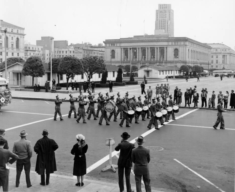 The Municipal Railway Drum and Bugle Corps marching in a parade, Civic Center, 1940s