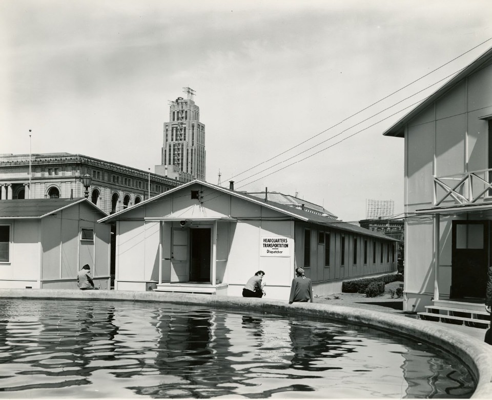 Three people sitting at a fountain in front of the Temporary Barracks, Civic Center Plaza, 1940s