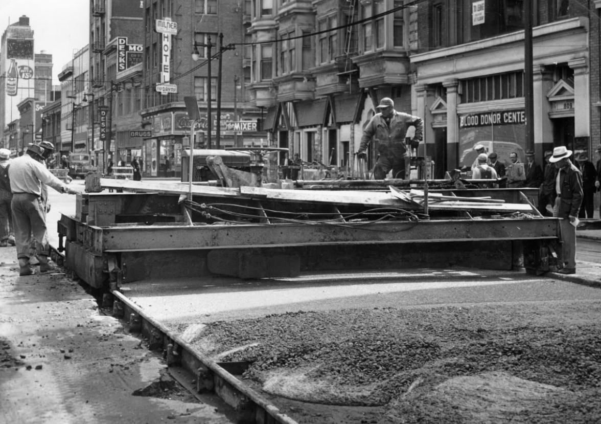 Workers operating a concrete spreader on Mission Street, 1944