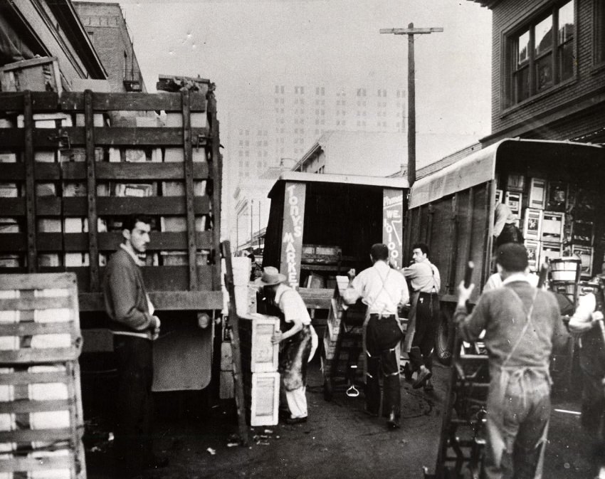 Delivery trucks being unloaded at the Commission District produce market, 1956.
