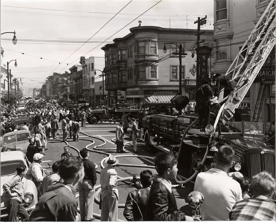 Firefighters combat a three-alarm fire at Haight and Ashbury Streets, 1952.