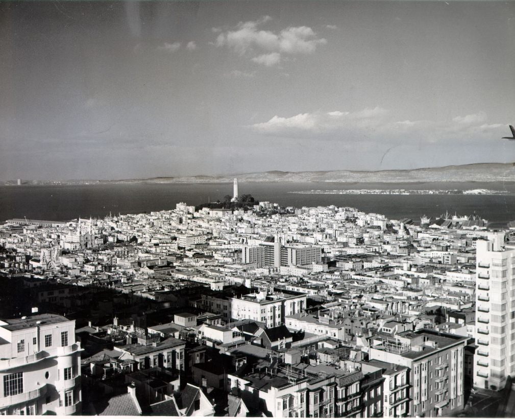 View from the 18th floor of an apartment building at 1200 California Street, with Coit Tower and Treasure Island visible, 1962.
