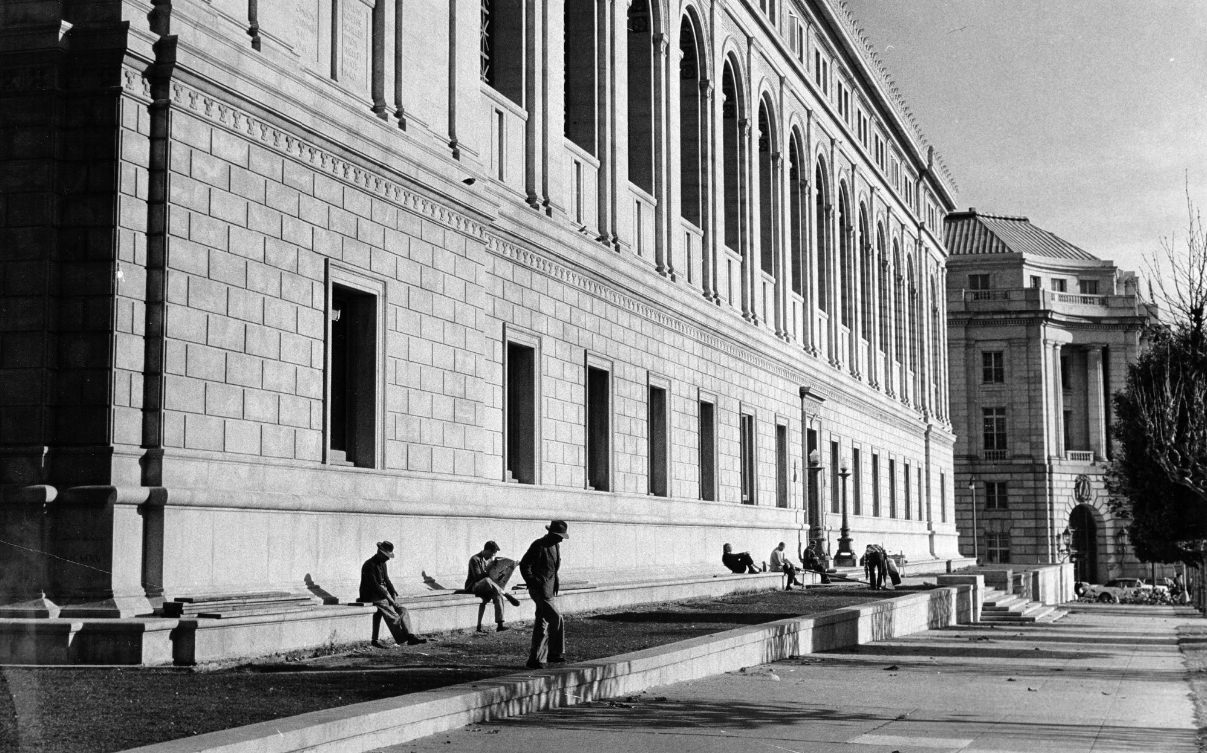 People sitting along the south wall of the Main Library, 1960.