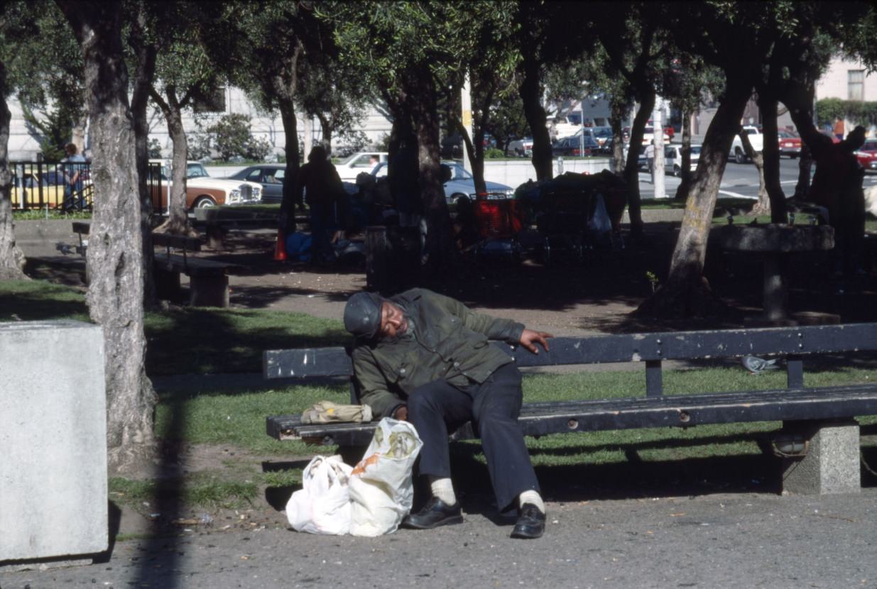 Man sleeps on a bench at Civic Center, 1989.