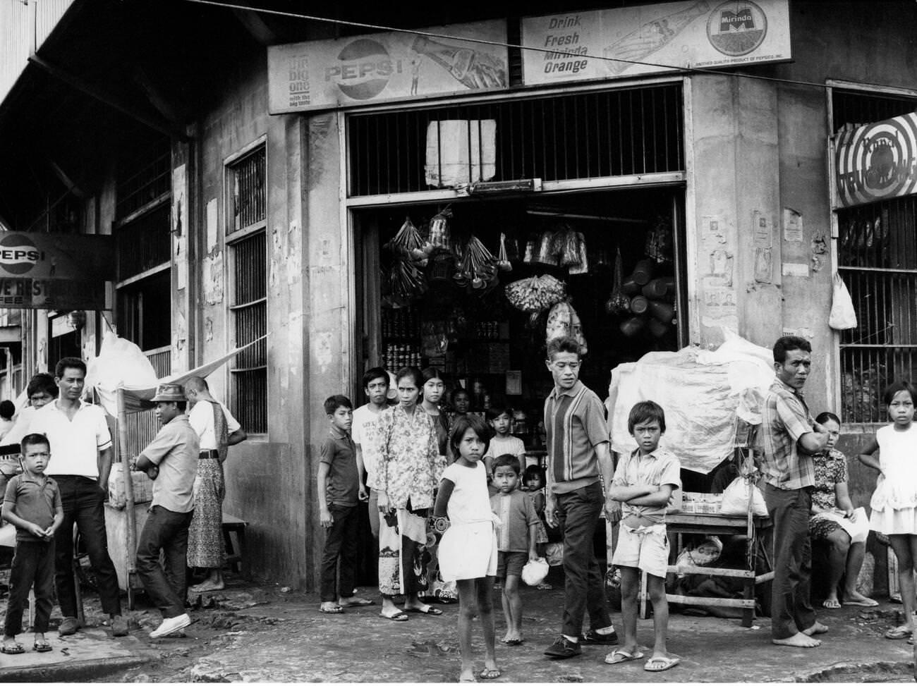 Street scenes in Jolo, Philippines, with people in front of a grocery shop, 1972.