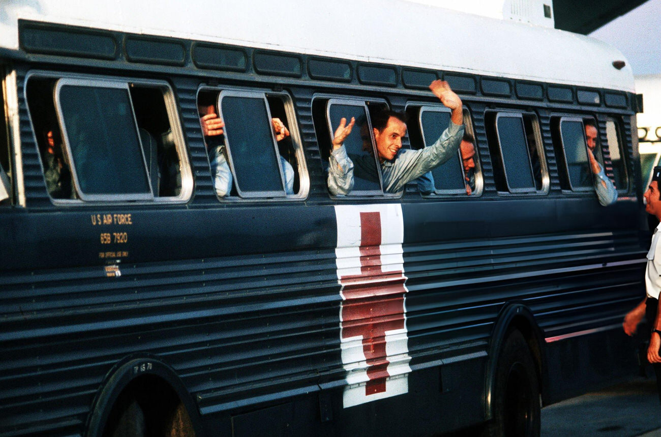 An American POW waves from a hospital bus at Clark Air Base, Luzon, Philippines, after being released from a North Vietnamese camp, January 1973.