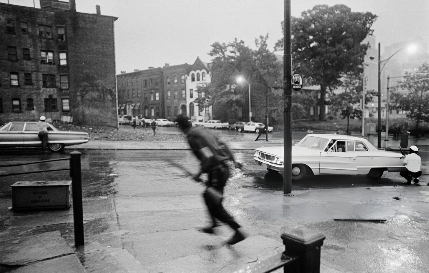 Police take cover behind parked cars during the riots in Newark, New Jersey, 1960s.