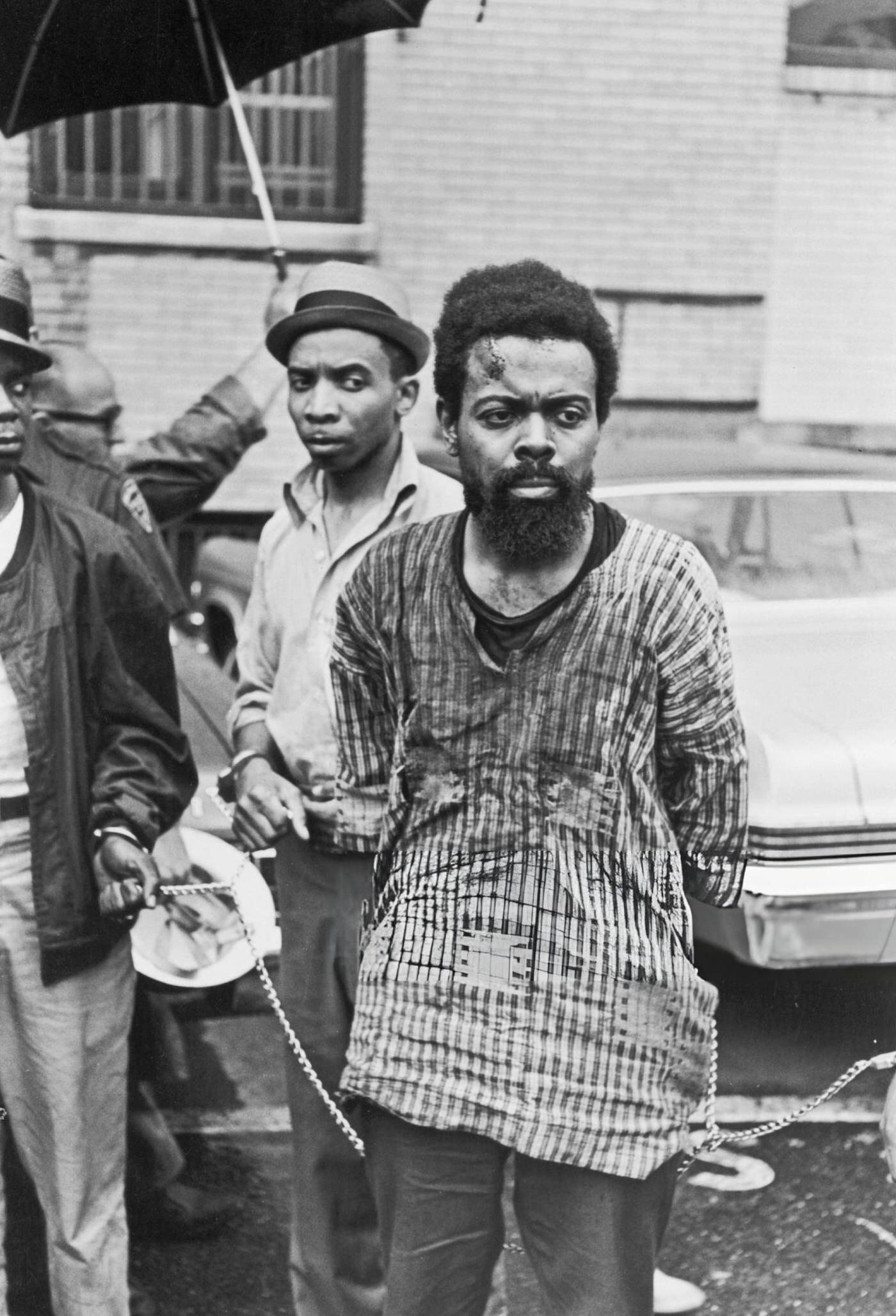 LeRoi Jones leaves a police station bloodied and in chains after being arrested