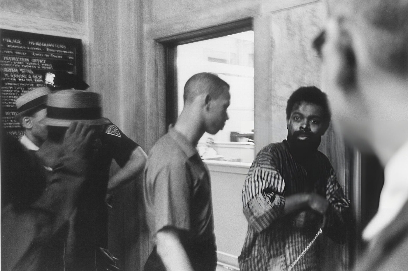 LeRoi Jones in a police station, bloodied and in chains after being arrested.