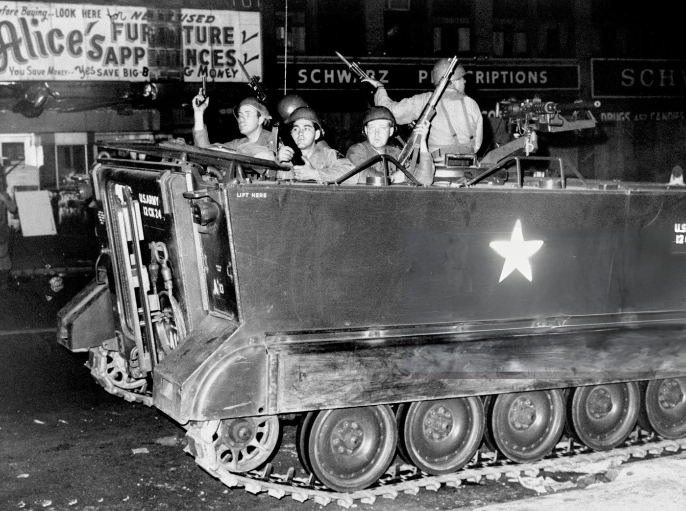 Soldiers in an armored personnel carrier patrol the streets of Newark