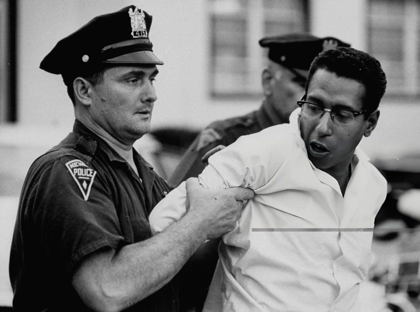 A policeman arrests a suspect during riots, 1960s.