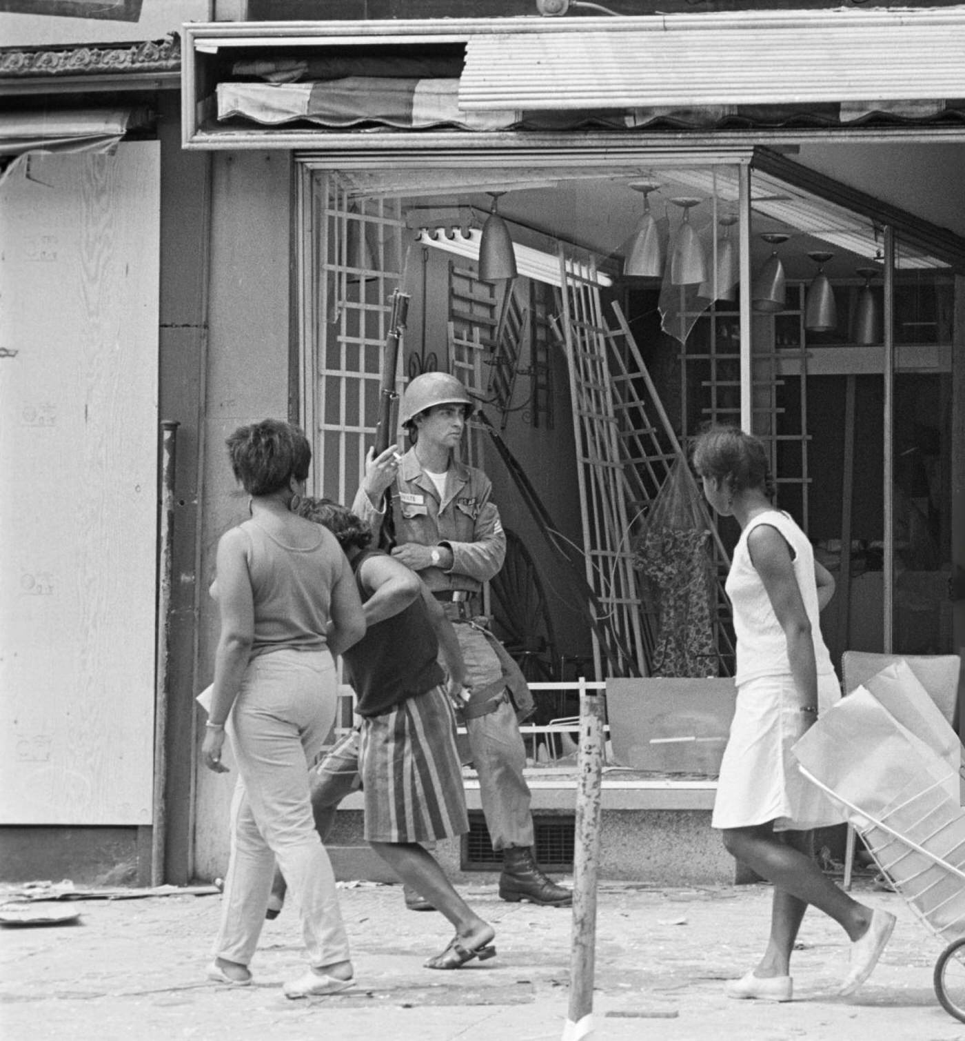 A National Guard soldier stands guard in front of a looted and gutted store