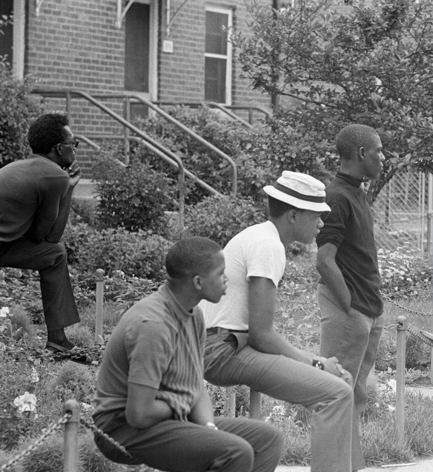 Young African Americans on the sidewalk of an avenue lined with brick houses