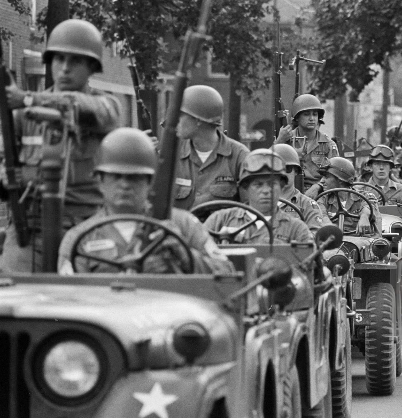 A regiment of the federal guard and state police driving jeeps in single file on an avenue