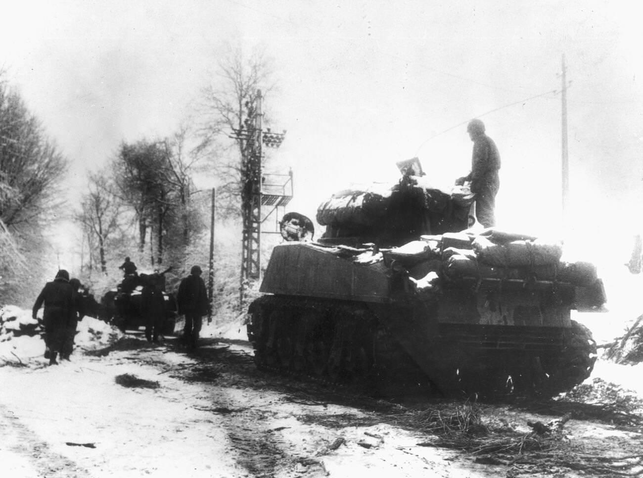 Tanks and infantrymen of the 82nd Airborne Division push through the snow in Belgium, 1944.