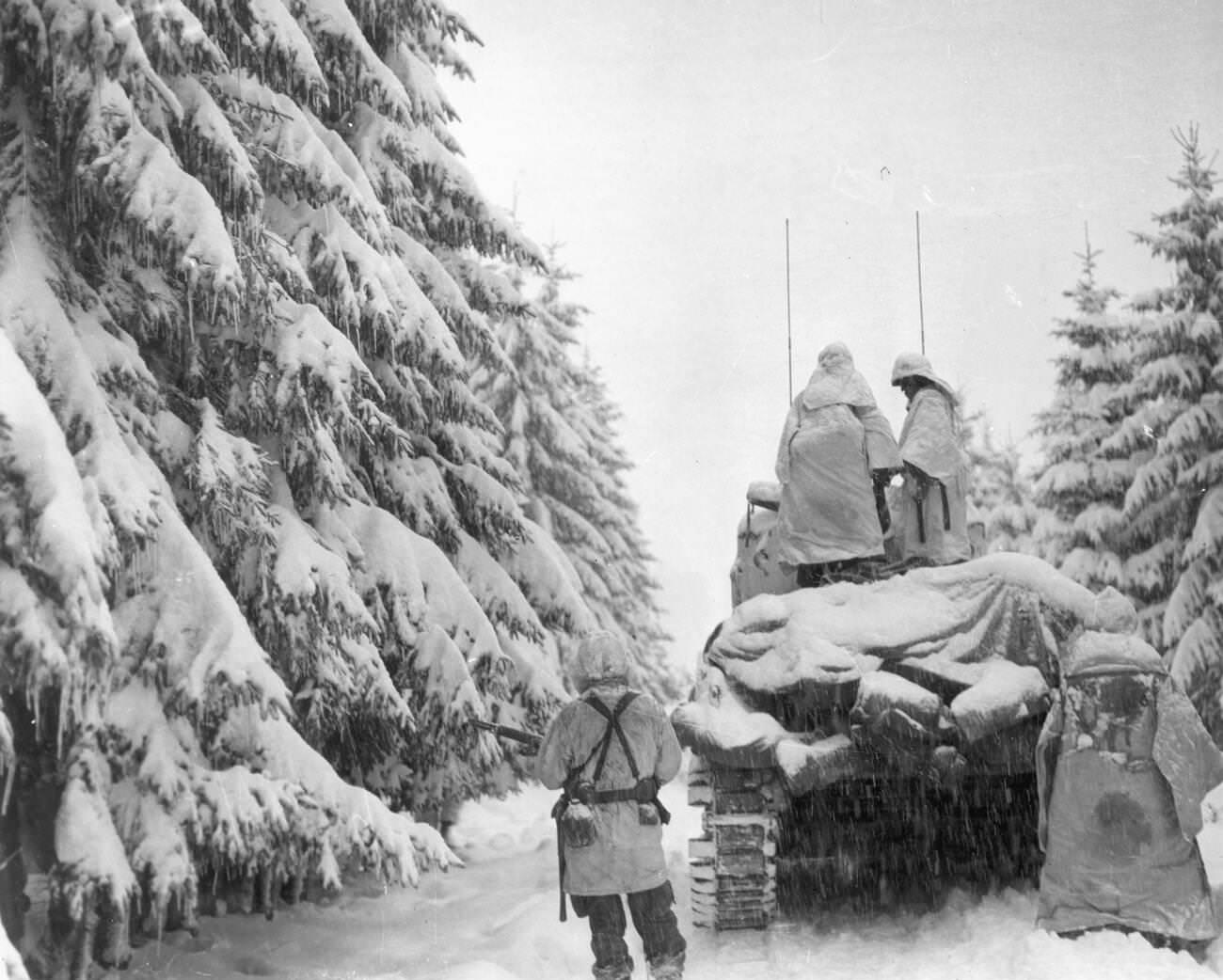 Tanks and infantrymen of the 82nd Airborne Division push through the snow in Belgium, 1944.