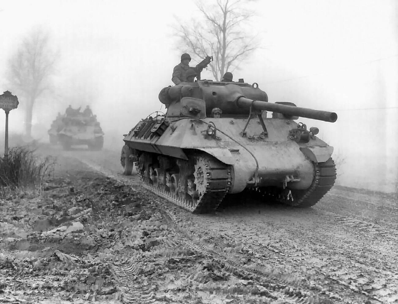 American tank destroyers move forward during heavy fog to stem the German spearhead near Werbomont, Belgium, 1944.