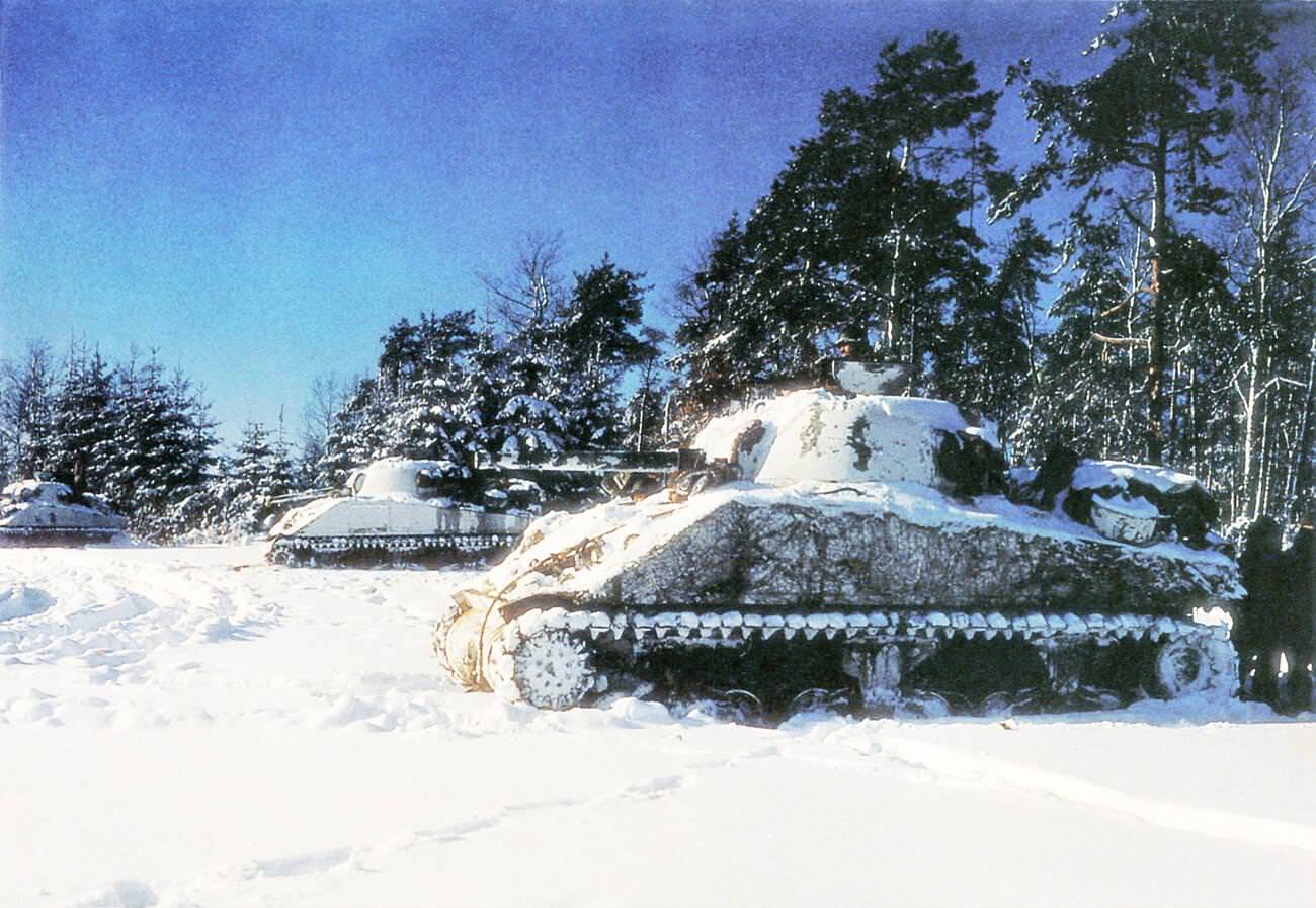 Three American M4 Sherman tanks near St. Vith during the Battle of the Bulge, 1944.