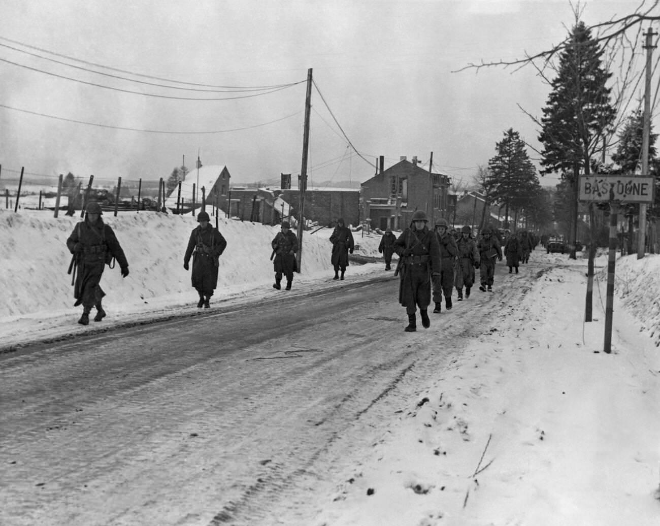 Members of the 101st Airborne Division move out of Bastogne to drive the Germans who besieged them for ten days out of a neighboring town, 1944.