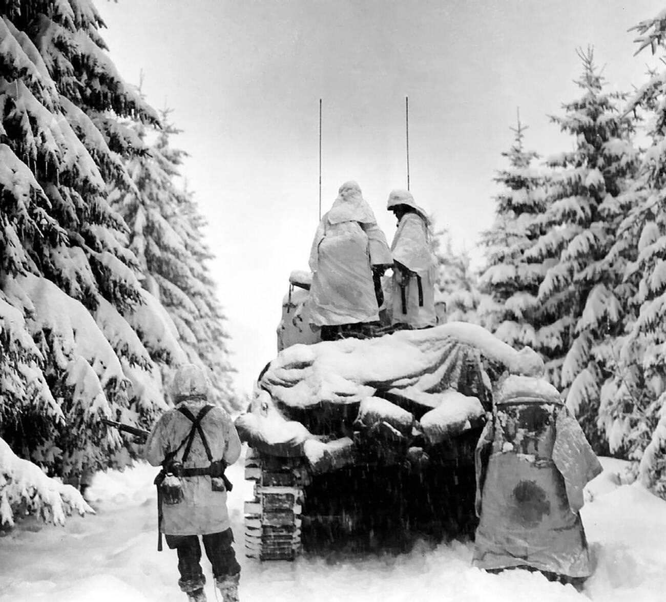 Tanks and infantrymen of the U.S. Army’s Company G, 740th Tank Battalion, 504th Regiment, 82nd Airborne Division, push through the snow toward their objective near Herresbach, Belgium, 1945.