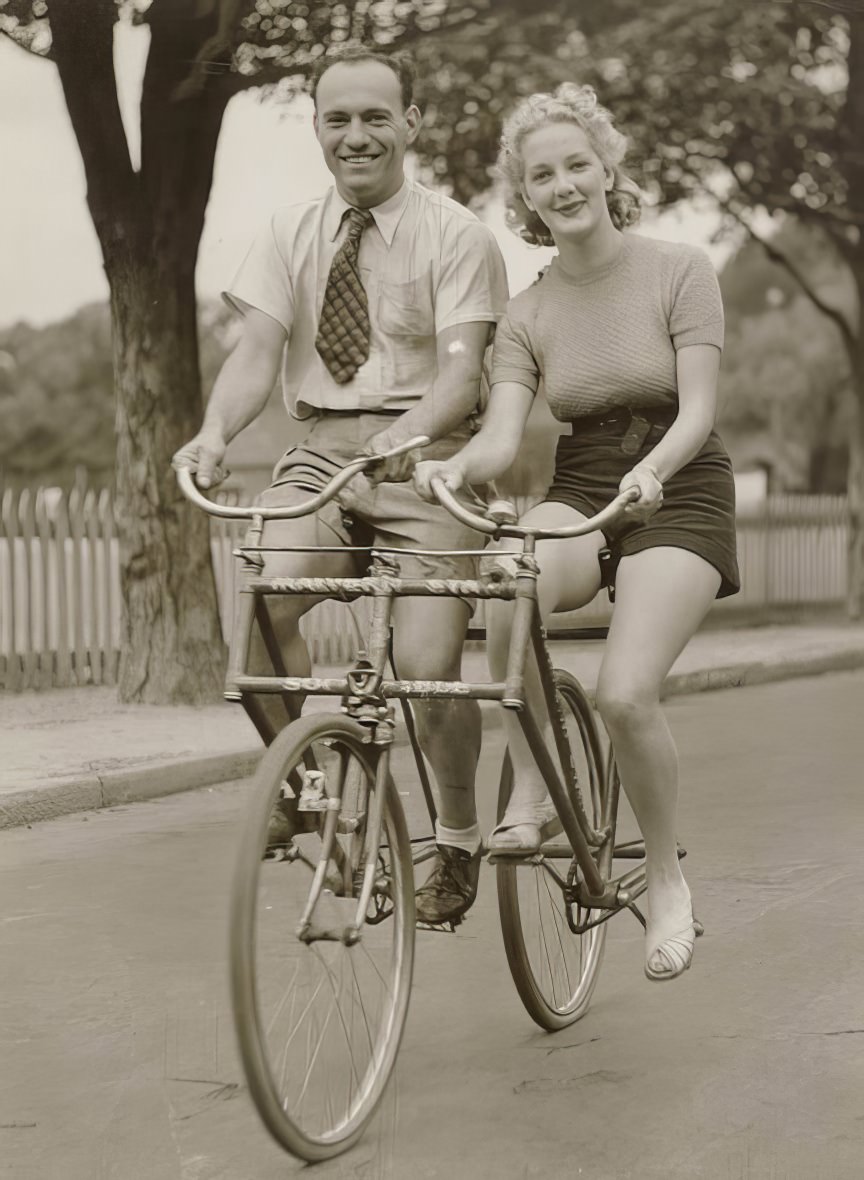 A man and woman on a Malvern Star abreast tandem bicycle, 1930s.