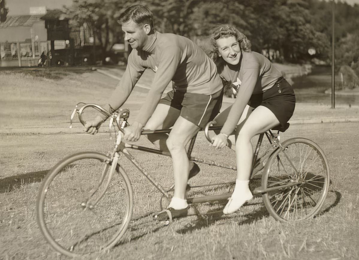 Oppy (Hubert Opperman) and a woman, possibly Edna Sayers, on a tandem bicycle.