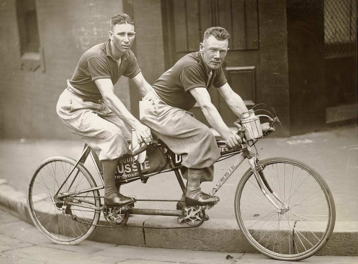 Two men in plus-fours on a tandem .