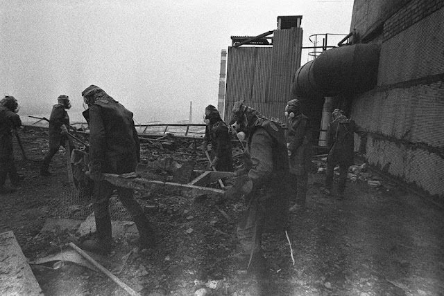 Liquidators clear radioactive debris from the roof of the No. 4 reactor, throwing it to the ground where it will later be covered by the sarcophagus.