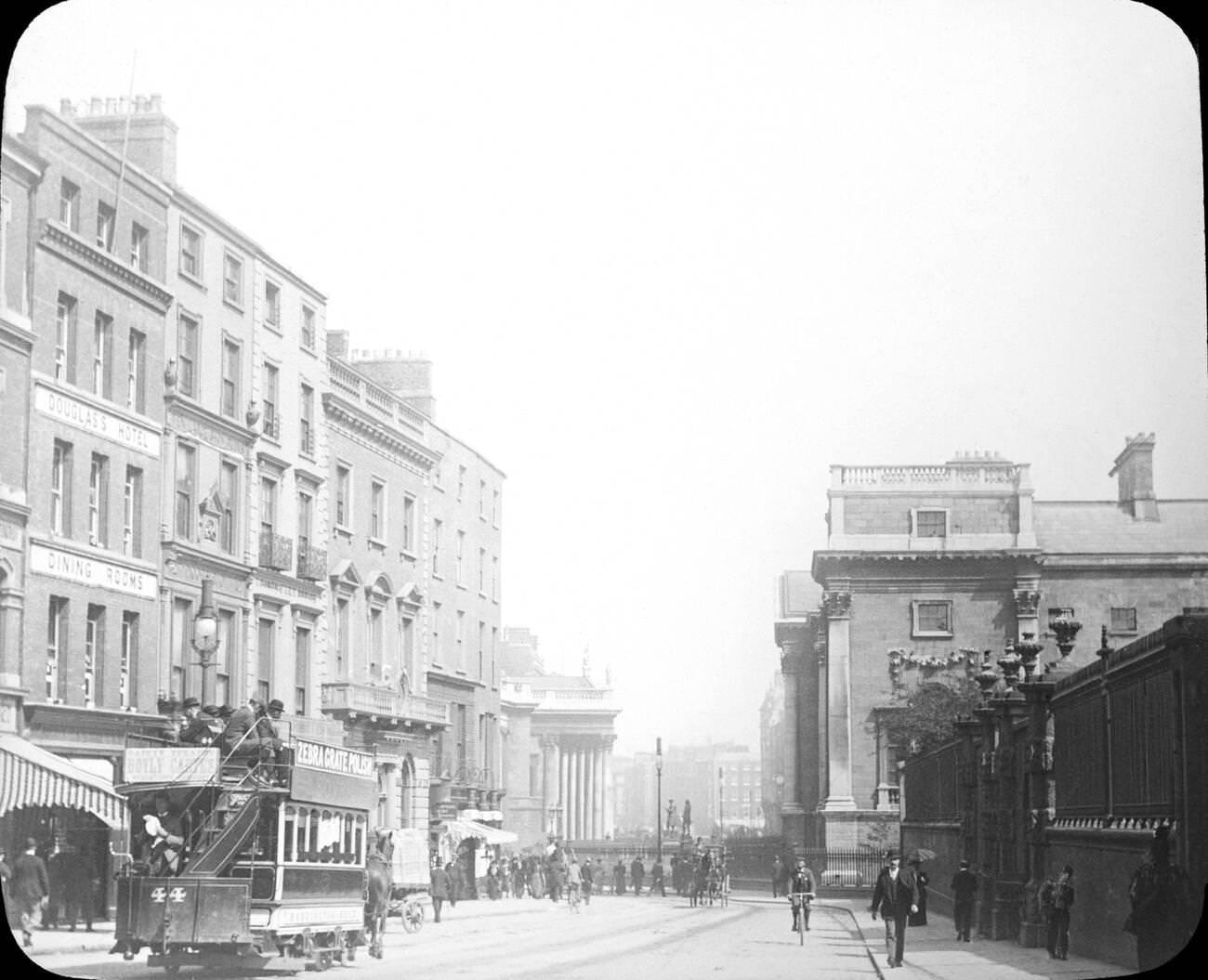 View looking down Grafton Street in Dublin during Victorian times. The Douglas's Hotel and Dining Rooms are visible on the left, and the number 44 horse drawn tram shows adverts for Zebra Grate Polish.