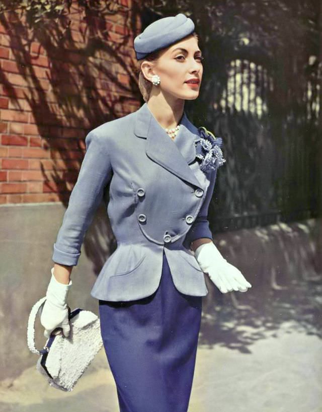 Geneviève Richard in a summer suit of lilac and purple linen, the curved jacket has a bib front by Pierre Balmain, 1954.