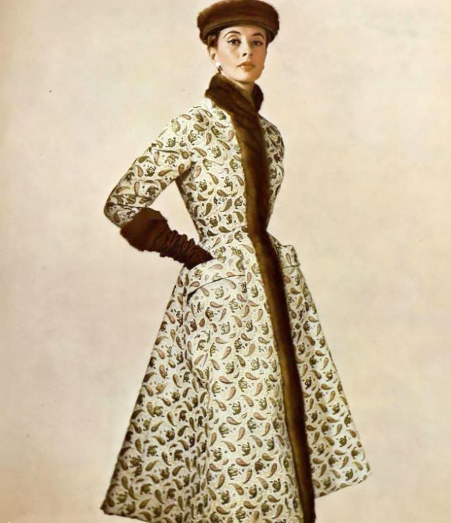 Marie-Thérèse in a gold brocade coat of Persian design, a high stand-up collar of mink that extends down the front, by Pierre Balmain, 1954.