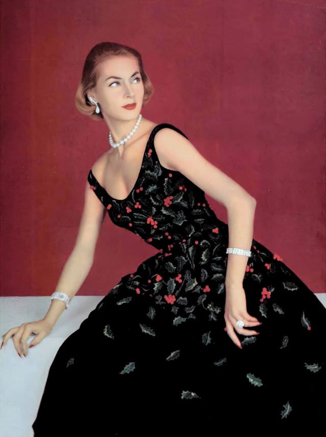 Ghislaine Arsac in the perfect holiday dress, black velvet embroidered with sprigs of green holly and red berries by Pierre Balmain, 1955.