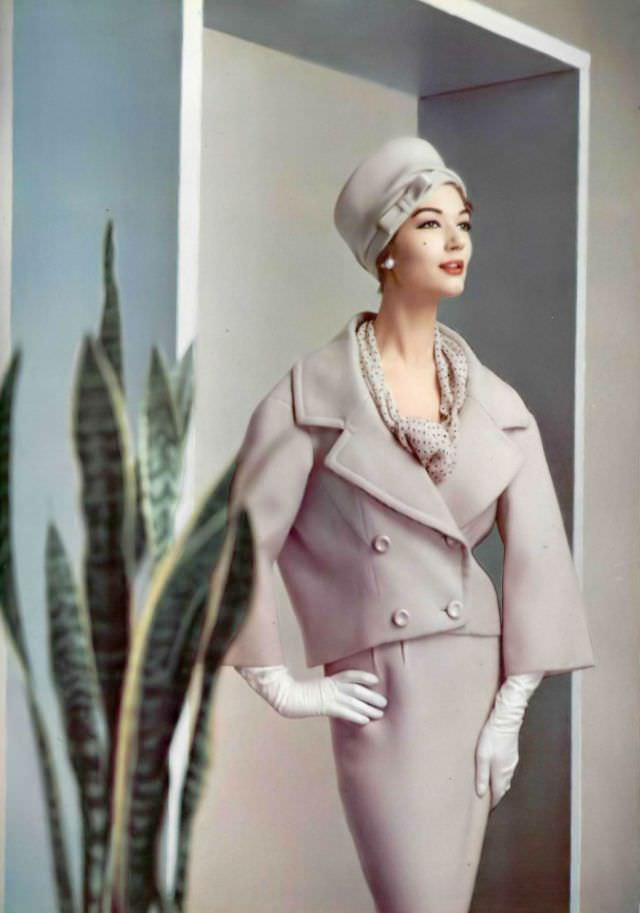 Simone d'Aillencourt in a lilac wool suit, the collar and lapels are widened and the jacket tilts slightly to the back, by Pierre Balmain, 1957.