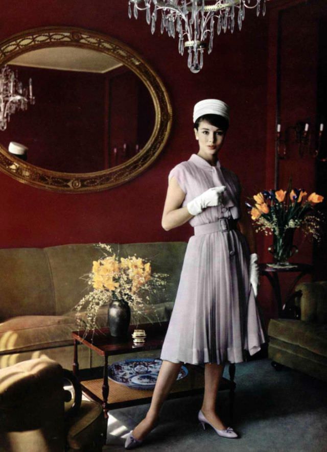 Sondra Peterson in a pale lilac silk mousseline dress, belted and pleated by Pierre Balmain, 1959.