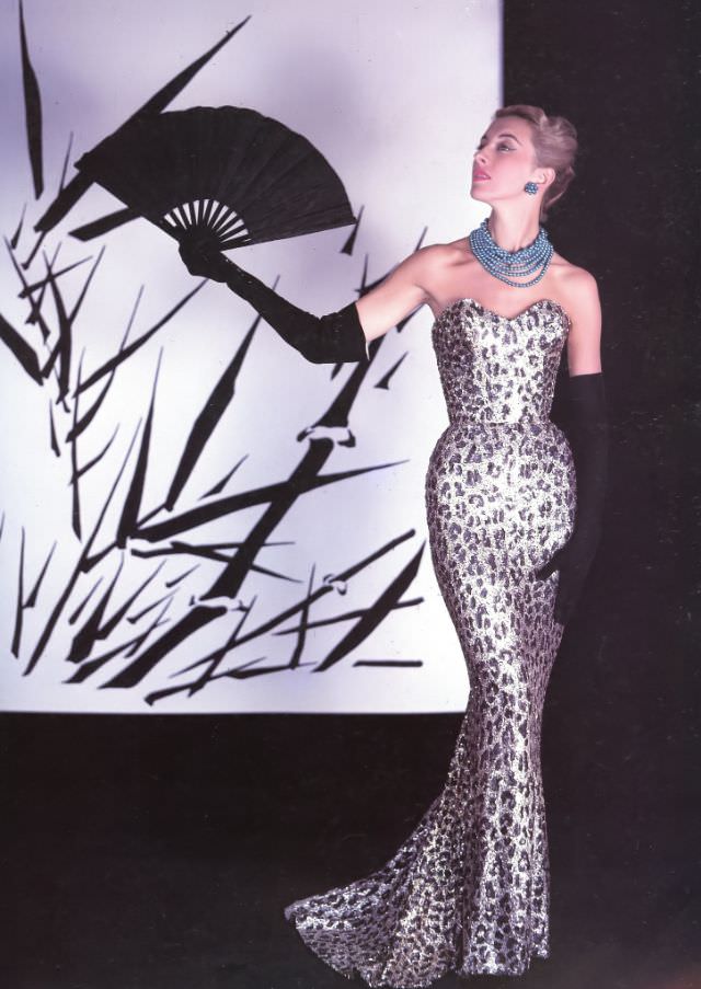Marie-Thérèse in Balmain's famous sheath of embroidered paillettes in a leopard spot design, 1953.