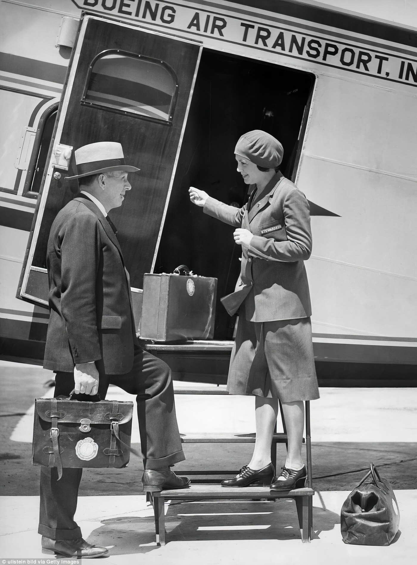 Miss Ellen E. Church, R.N., welcomes a passenger to Boeing Air Transport’s Model 80, a three-engine biplane capable of carrying up to 12 passengers.