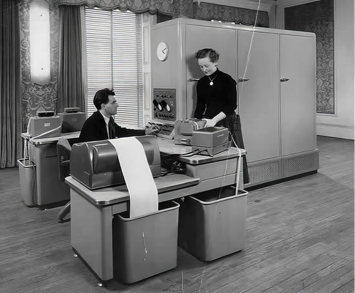 A man and woman working at a Ferranti Pegasus computer. This computer was a classic 1950s/1960s mainframe installation, taking up the majority of space in a room.