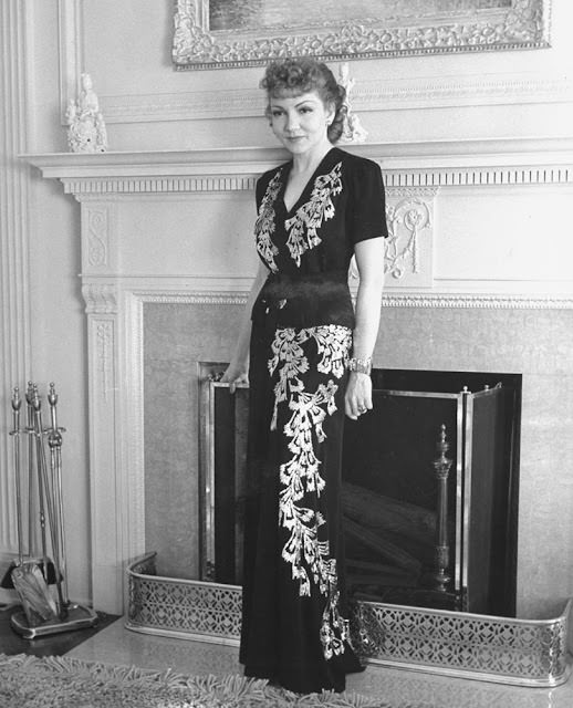 Claudette Colbert posing in a two-piece evening dress at her home in Los Angeles, 1939.