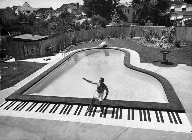 Liberace playing the piano at his California home, 1954.