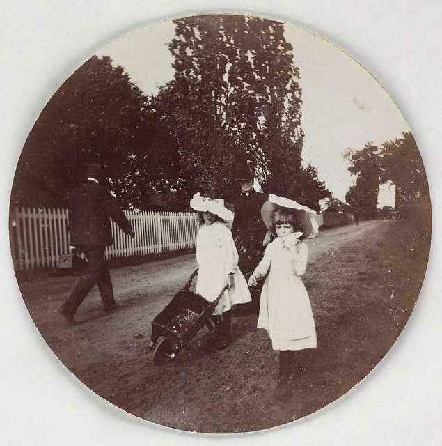 Children walking with a wheelbarrow