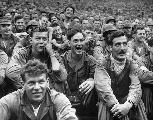 American and United Nations troops enjoy a Jack Benny performance at a USO show, 1951.